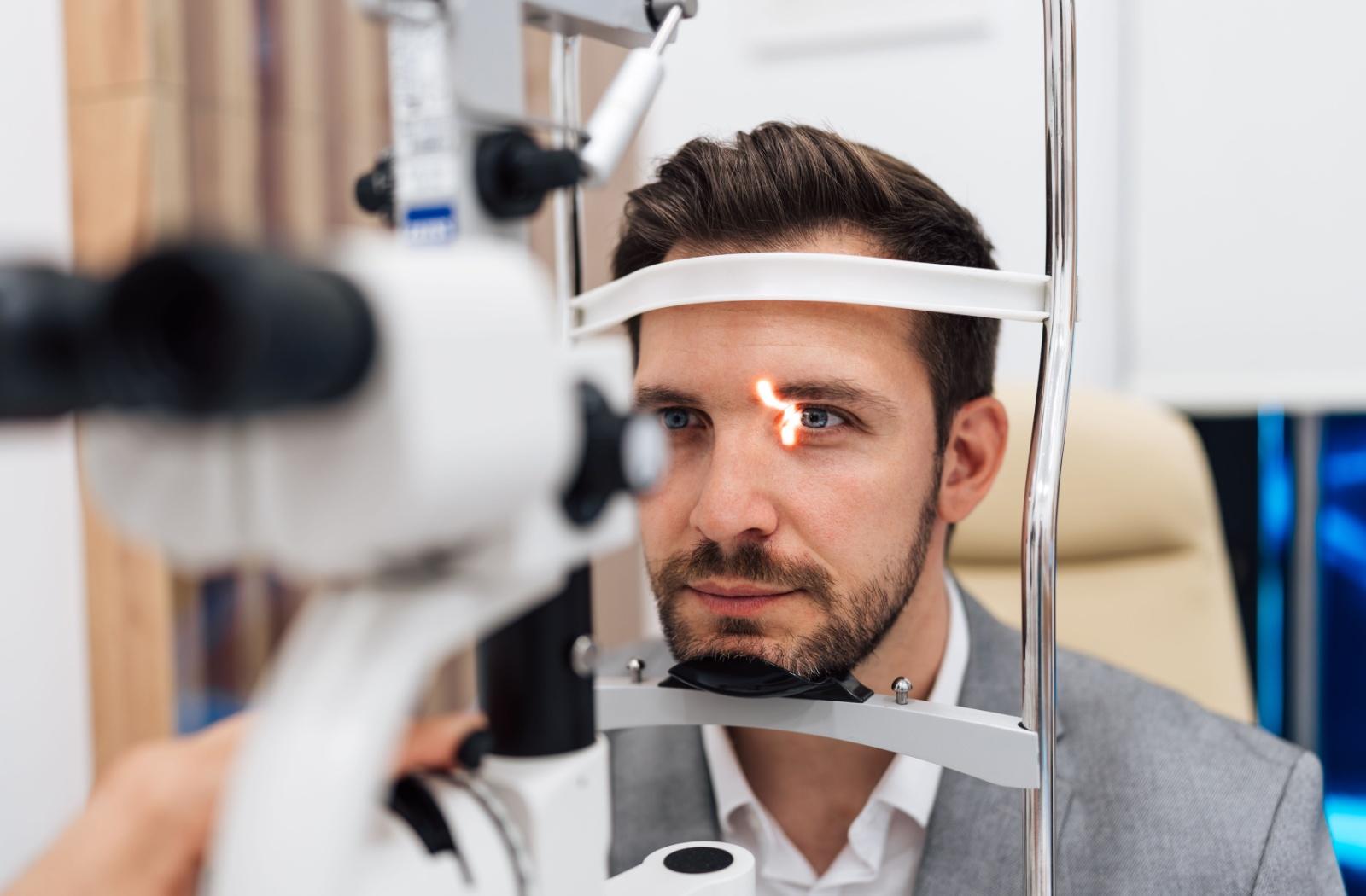 An adult gets their eyes examined by an optometrist.